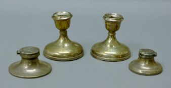 Two silver inkwells and a pair of damaged silver candlesticks. The latter 8.5 cm high.