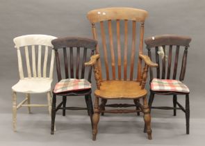 A Victorian elm seated splat back open armchair and three Victorian kitchen chairs.