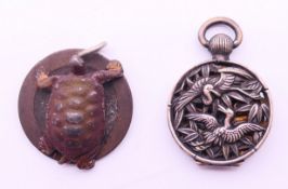 A Chinese silver pendant and a tortoise form pendant. Tortoise pendant 2.5 cm diameter.