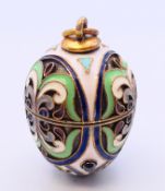 A silver and enamel egg pendant bearing Russian marks. 3 cm high.