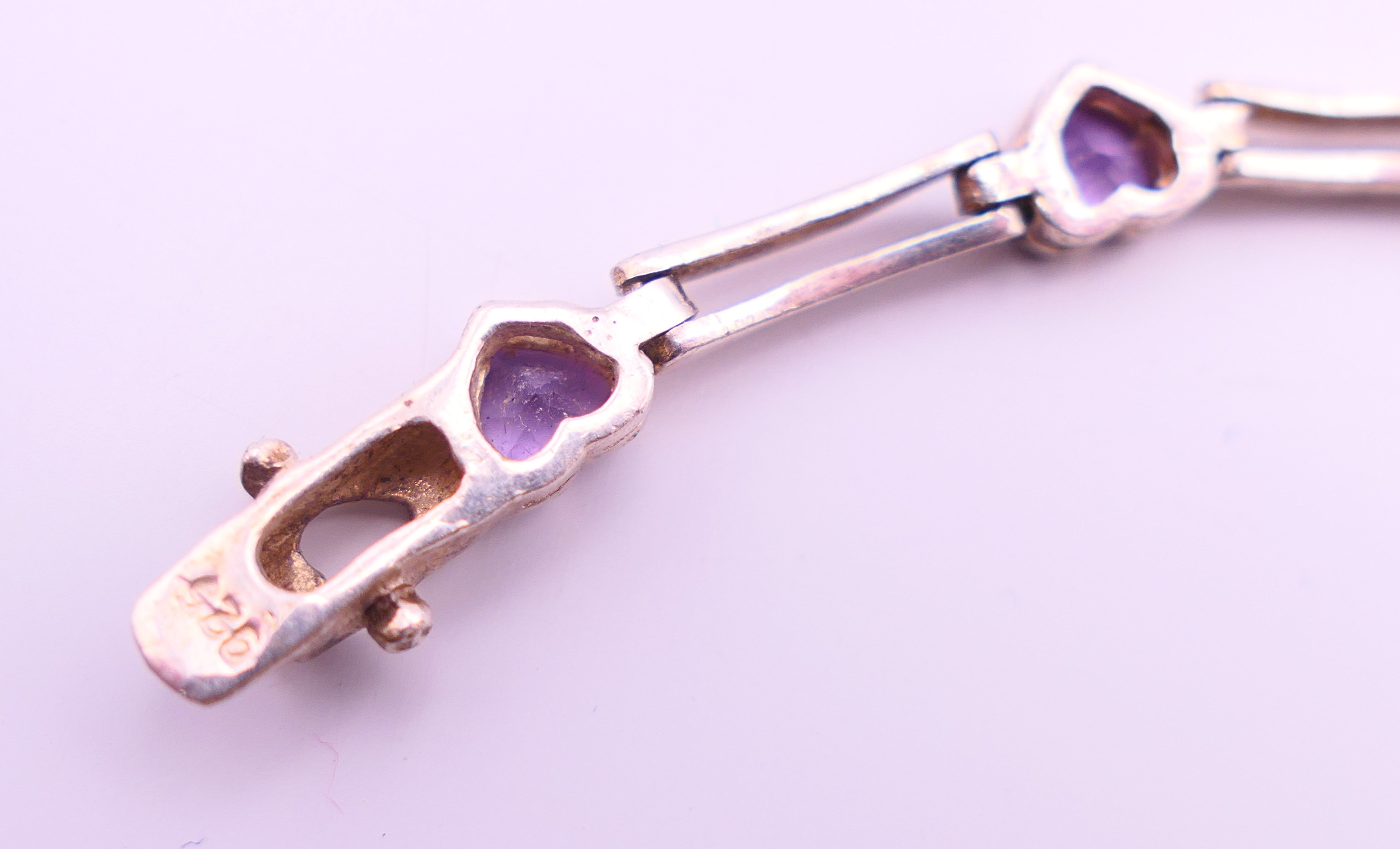 A silver bracelet set with heart shaped amethysts. 17 cm long. - Image 4 of 4