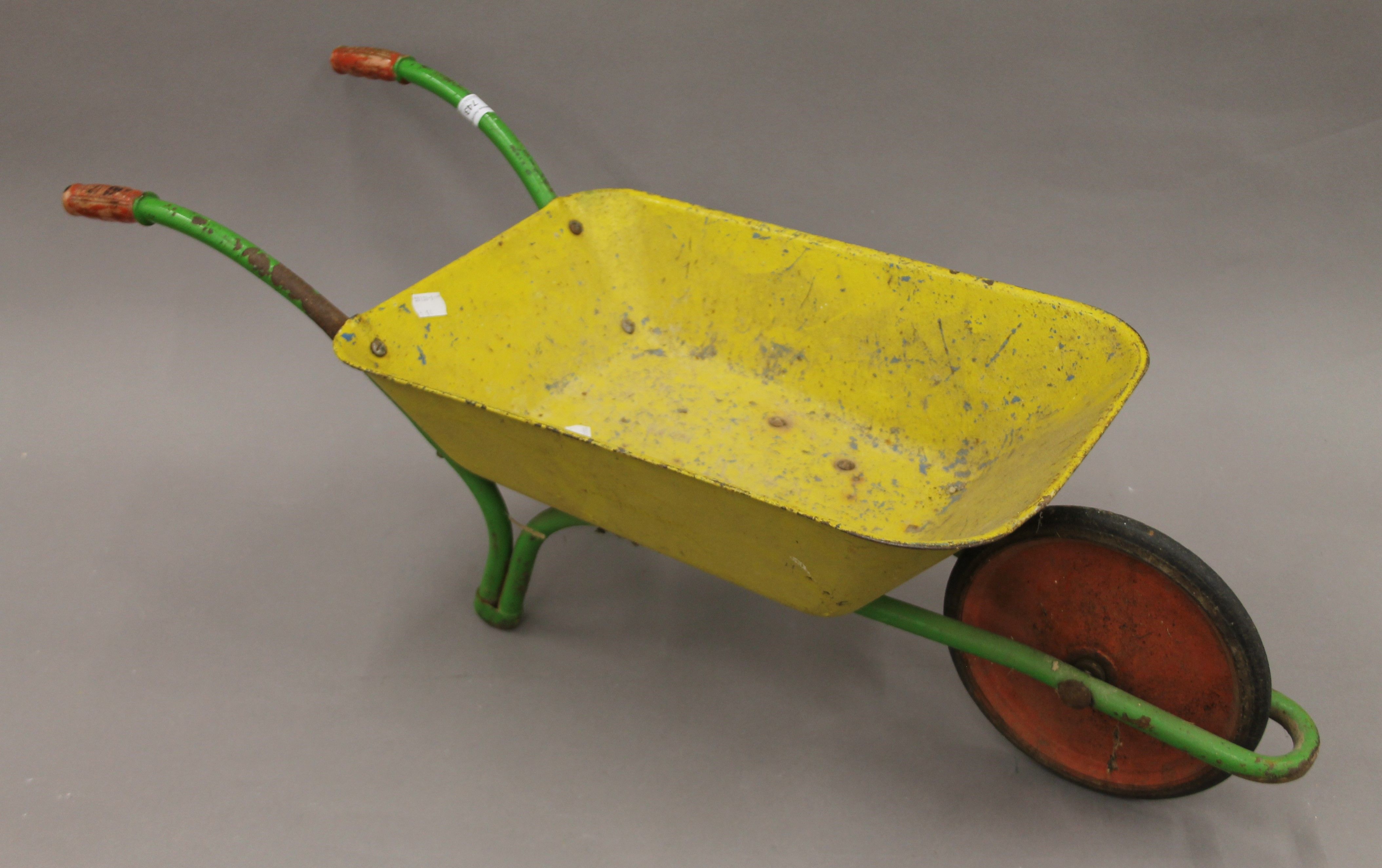 A vintage child's wheelbarrow. 82 cm long.