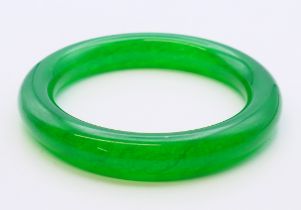 An apple green jade bangle. 6 cm internal diameter, external diameter is 8.5 cm.