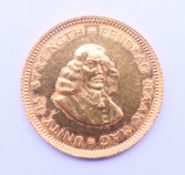 A 1967 South African 1 rand gold coin.