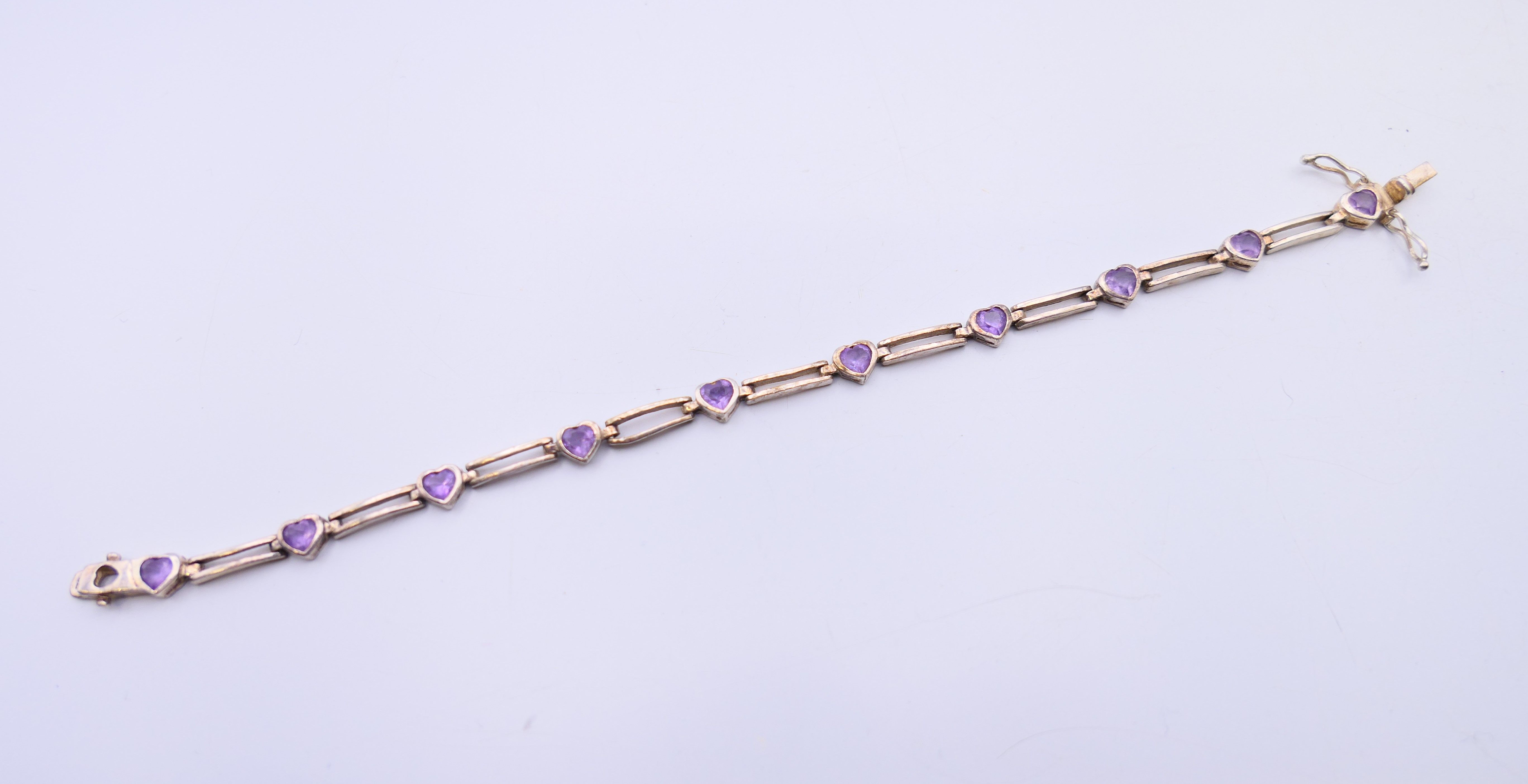 A silver bracelet set with heart shaped amethysts. 17 cm long. - Image 2 of 4