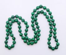 A string of malachite beads. 90 cm long.