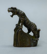 A bronze model of a tiger on a rock. 5 cm high.