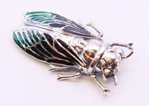 A silver brooch in the form of a beetle. 5 cm long.