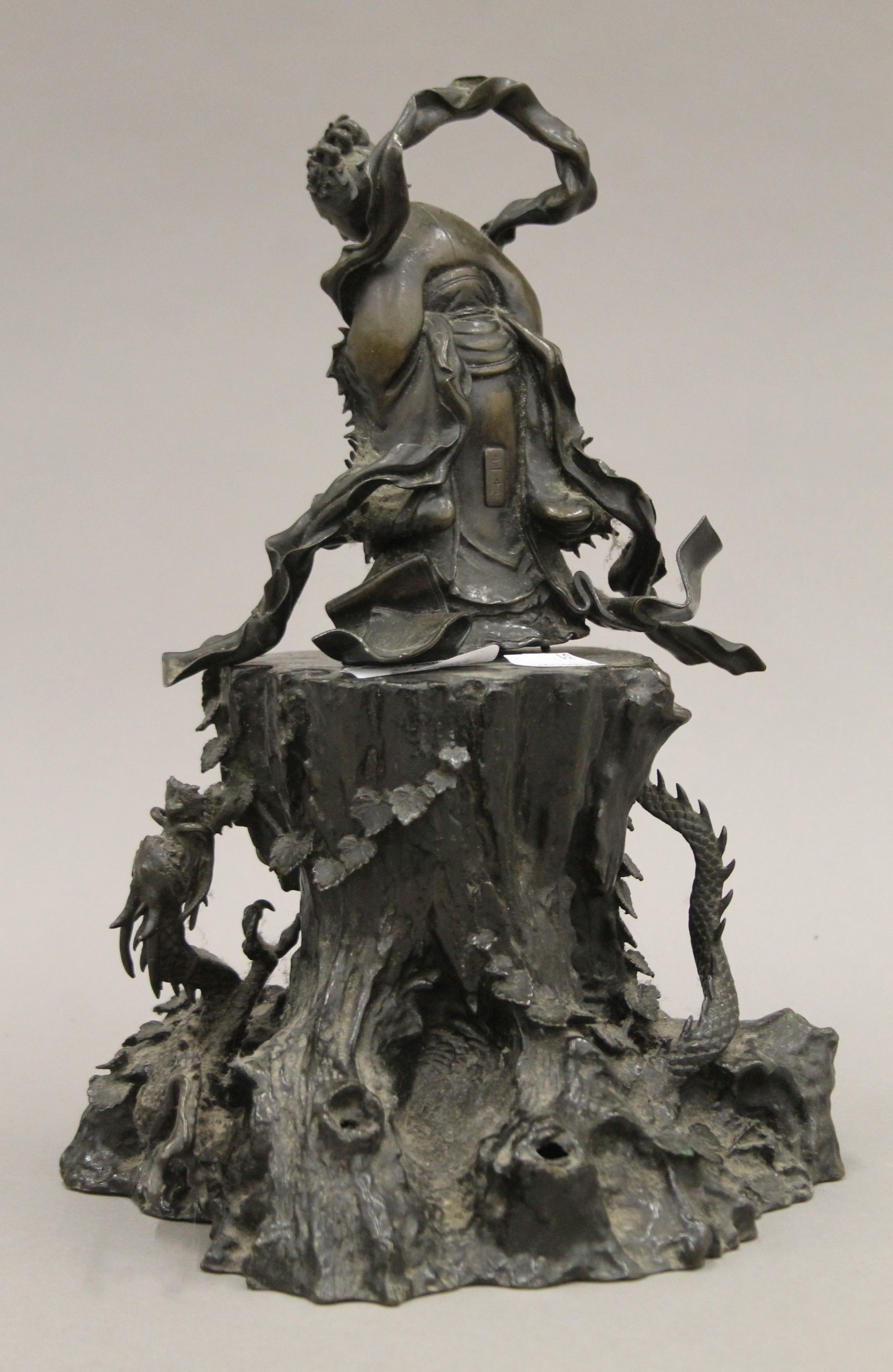 A 19th century Oriental bronze figure of Guanyin standing on a cast rockwork base with dragons. - Image 4 of 5