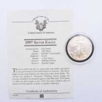 A 1997 USA 1 ounce fine silver one dollar coin with certificate of authenticity.