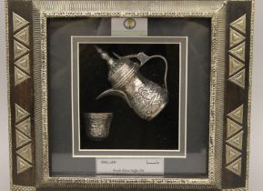A boxed and framed Saudi Arabian silver coffee pot. The box 30 cm wide.