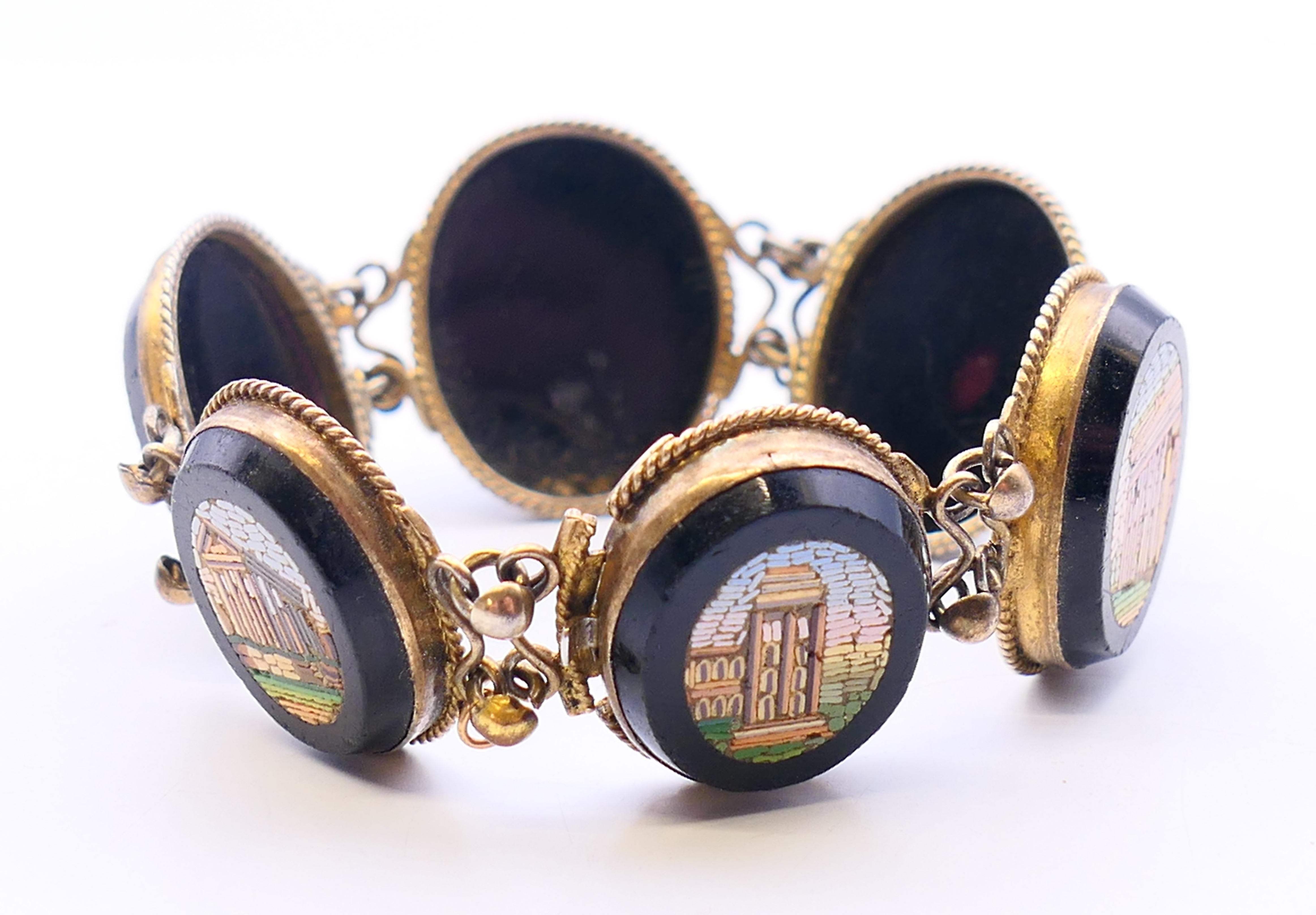 A 19th century micro-mosaic six panel brooch, the panels depicting Roman monuments. 18 cm long.