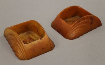 A pair of Art Deco amber Bakelite desk tidies, both stamped Carvacraft. Each 10 cm long.