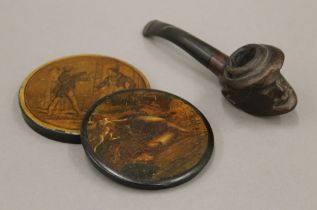 Two papier mache snuff box lids and a carved pipe. The latter 14.5 cm long.
