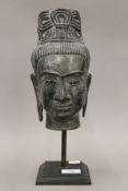 A bronze bust of an Eastern deity mounted on a later stand. 34 cm high overall.