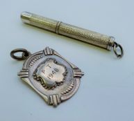 A silver hallmarked retractable toothpick and a silver fob engraved Eileen M Woollven March 1948.