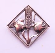 A silver brooch decorated with two doves with a wheatsheaf between. 3.5 cm high.