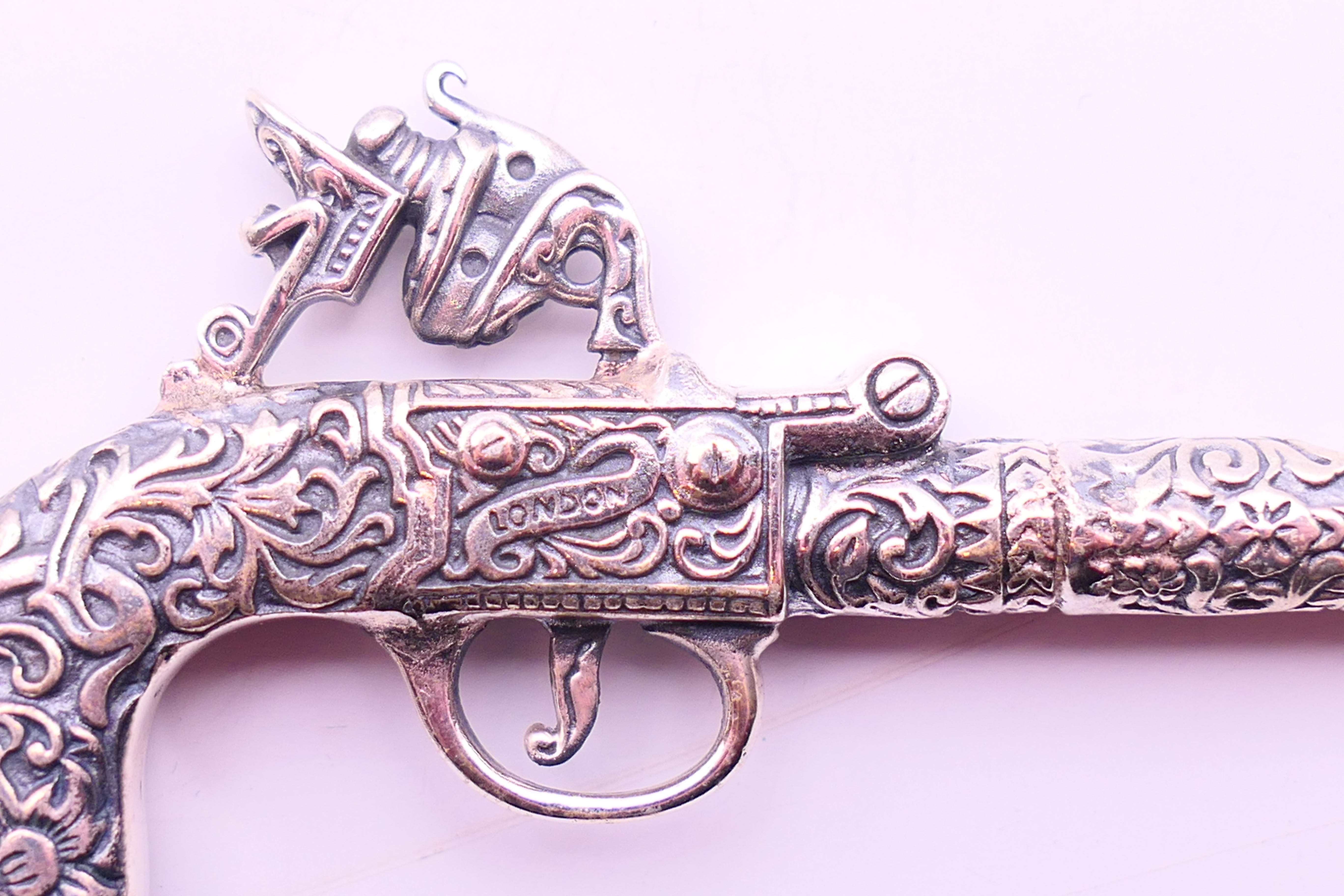 A silver pendant in the form of a pistol. 6.5 cm x 3.5 cm. - Image 3 of 3