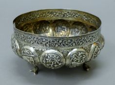 A 19th century Indian silver bowl, with lobed panels decorated with various animals and figures. 15.