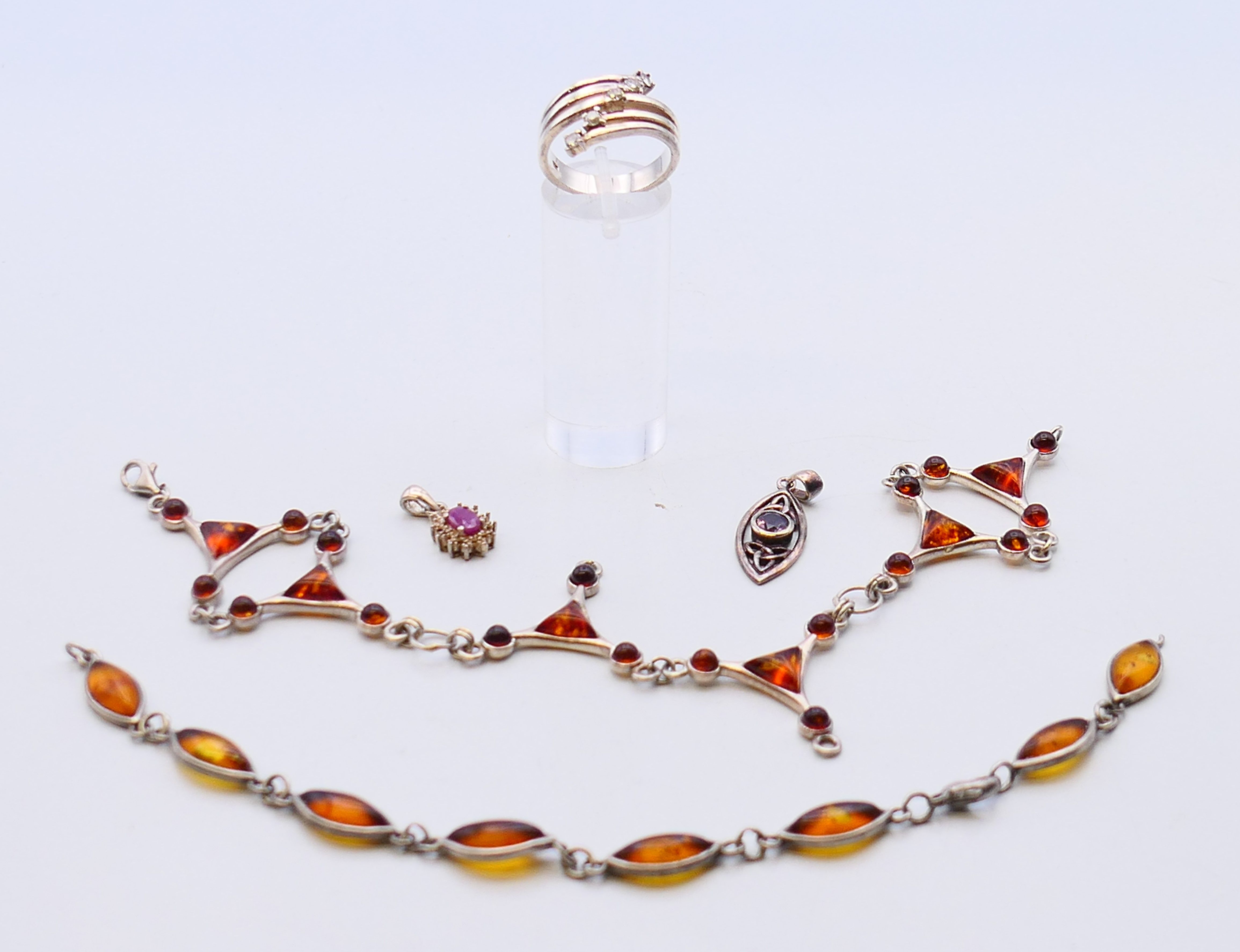 A collection of silver jewellery, including amber and pendants.