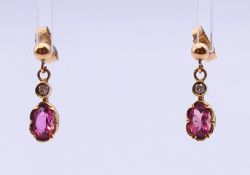 A pair of 9 ct gold oval pink gem earrings (believed to be tourmaline) with brilliant cut diamond.