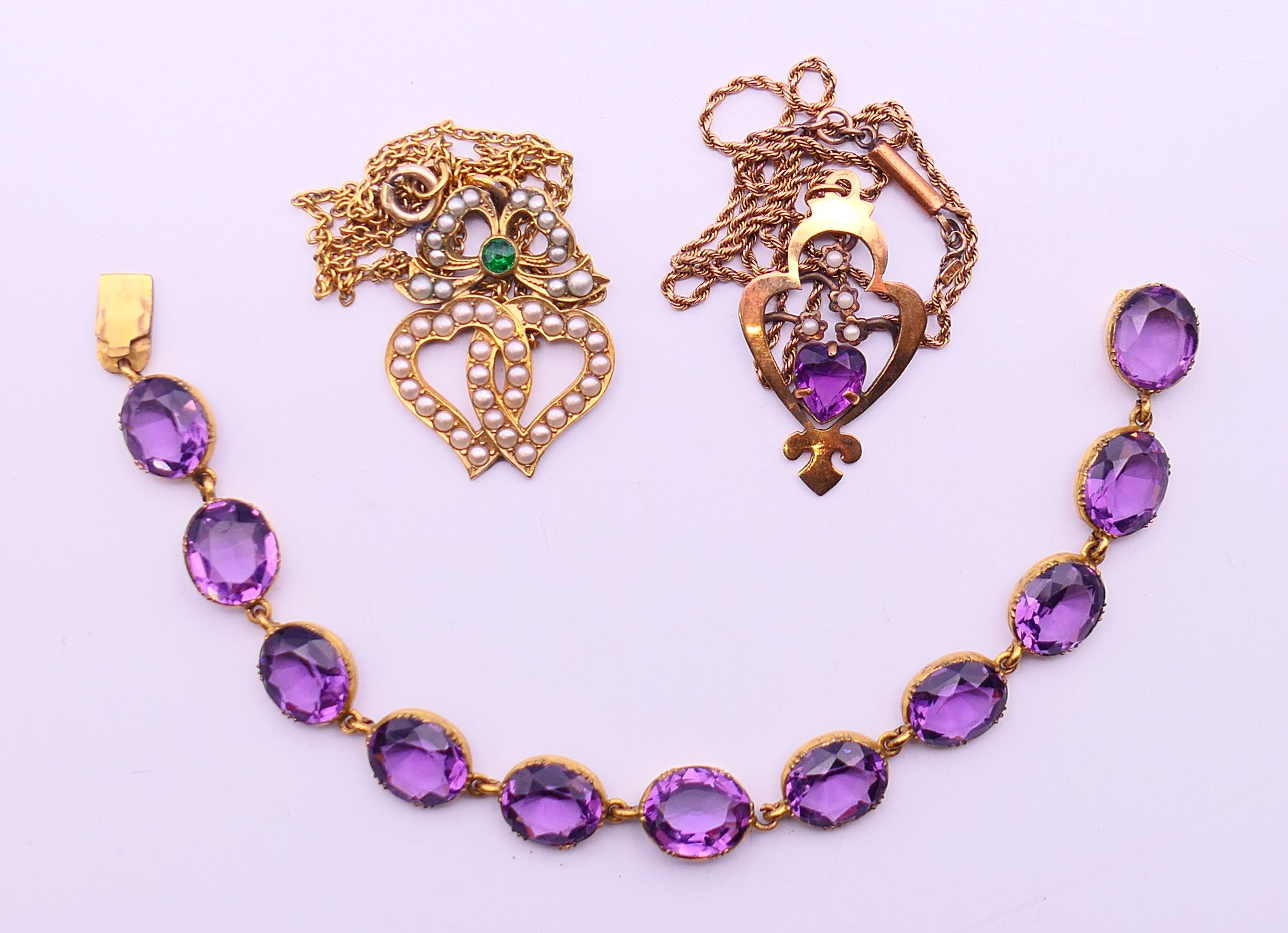 Two Edwardian pendant necklaces, one on a 9 ct gold chain, and a gilt metal and amethyst bracelet.