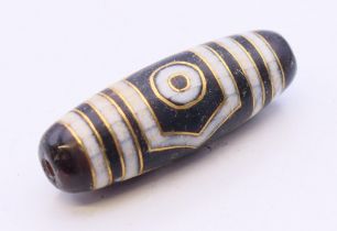 A gold inlaid dzi bead. 3.75 cm high.