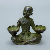 A bronze model of a boy holding two lily pads. 5.5 cm high.