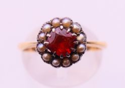 A 9 ct gold, seed pearl and garnet ring. Ring size O/P.