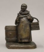 A cast bronze figure of a friar monk holding a key and candle. 18.5 cm high.