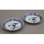 A pair of Chinese blue and white Wanli-style saucers painted with a bouquet of lotus within a key