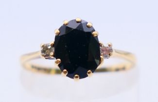 A 9 ct gold, diamond and sapphire three stone ring. Ring size K/L.