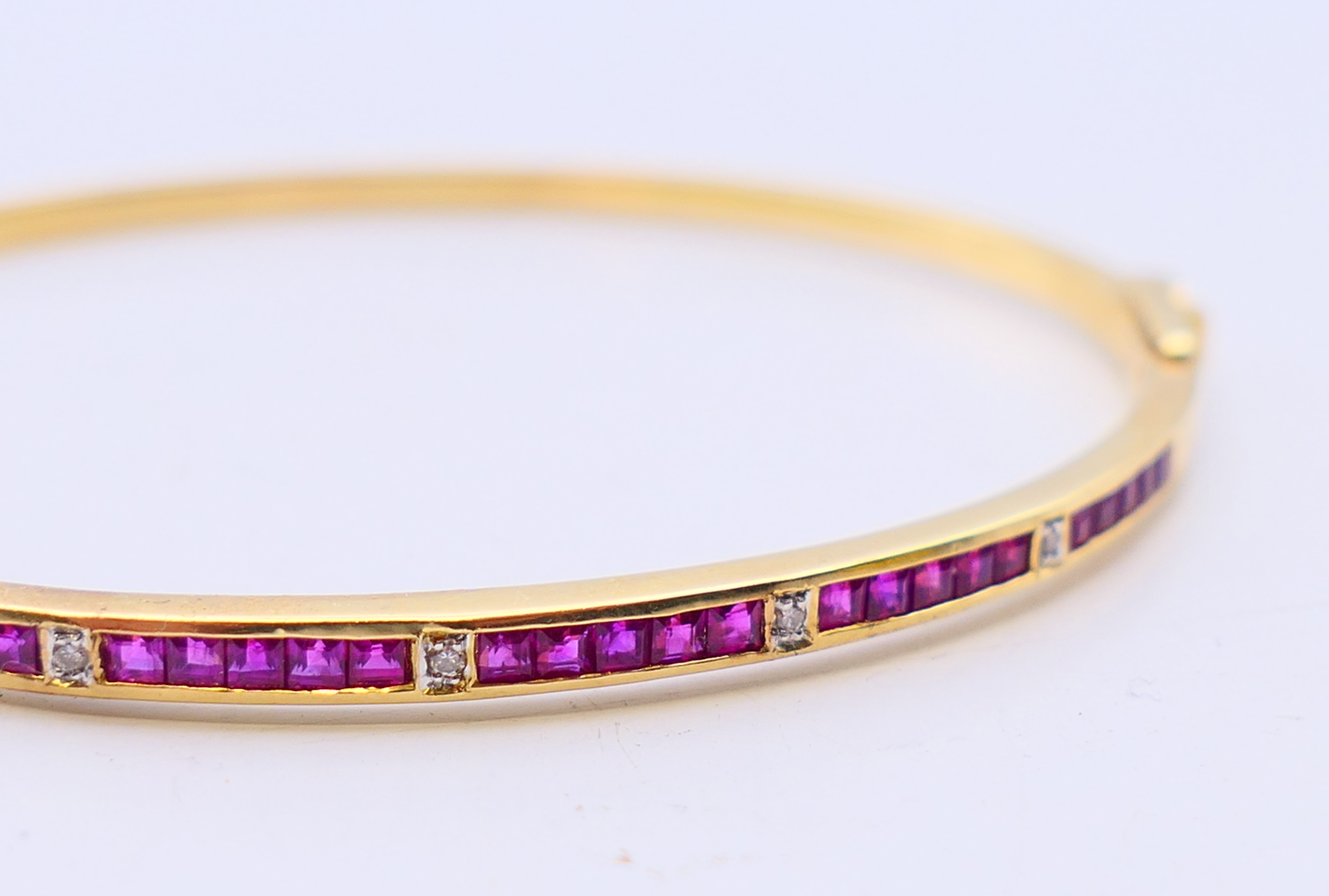 An 18 ct gold, ruby and diamond hinged bangle with twenty-five square shaped rubies (2mm), - Bild 2 aus 5