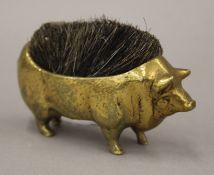 A brass pen wipe formed as a pig. 11 cm long.