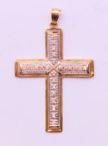 A 9 ct gold and diamond cross. 4.6 grammes total weight. 5 cm high including suspension loop.
