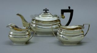 A silver three piece tea set. The teapot 26 cm long. 704.6 grammes total weight.