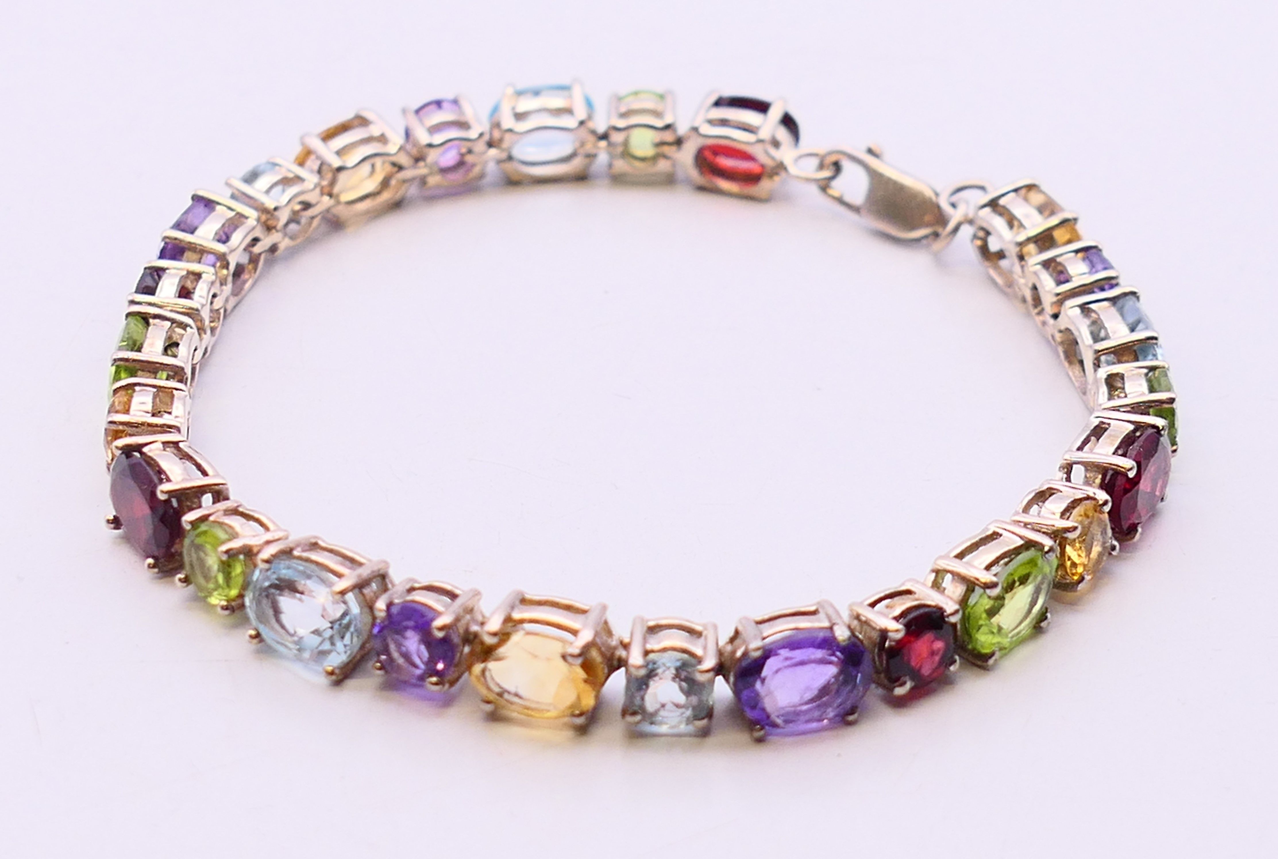 A silver multi gemstone bracelet. 19 cm long.