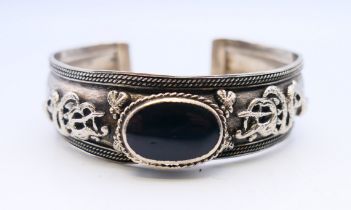 A silver bangle. 6.5 cm wide.