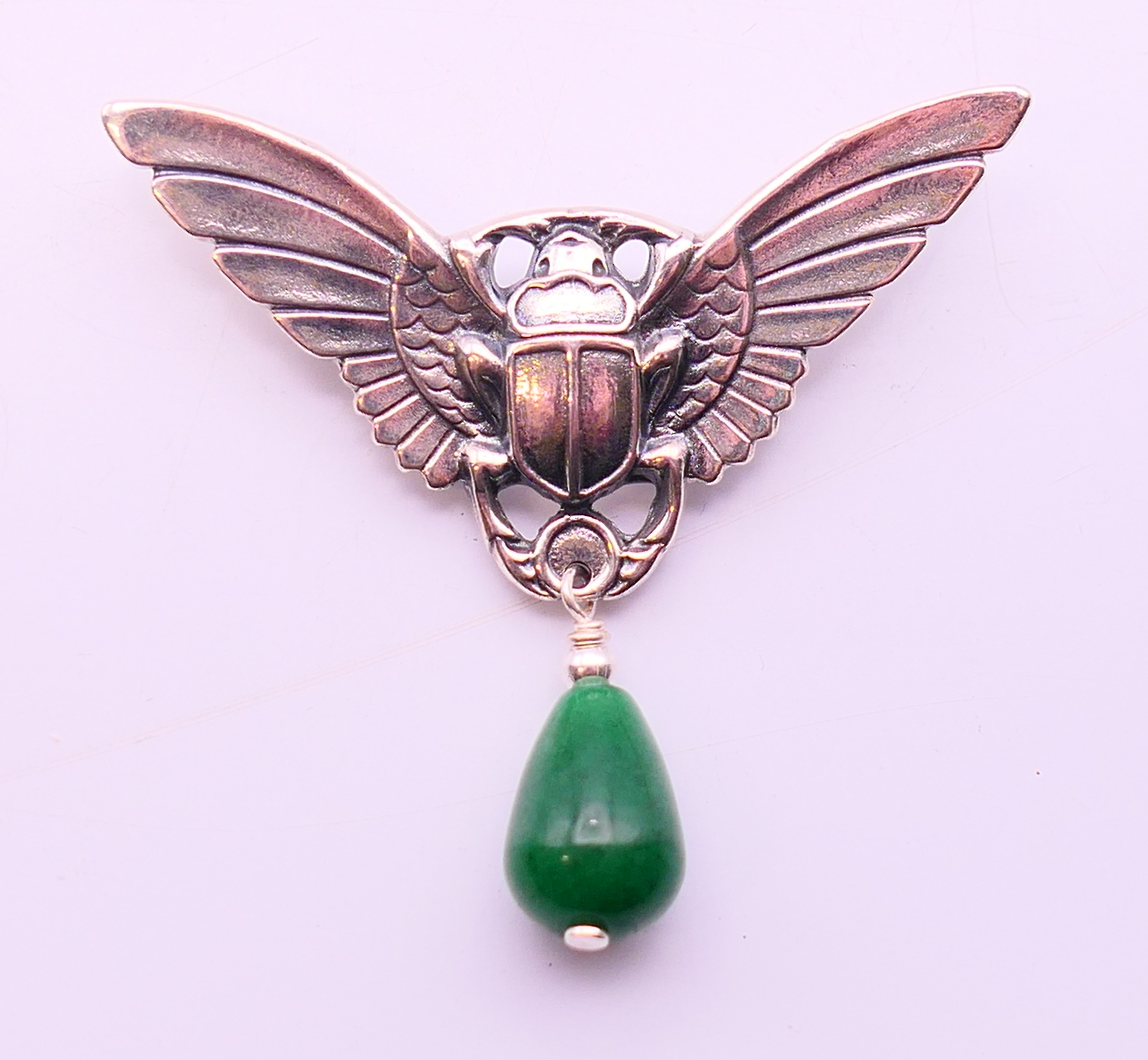 A silver and jade brooch in the form of a winged scarab beetle. 5 cm high x 5.5 cm wide.