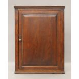 A George III elm hanging corner cupboard. 104 cm high, 77 cm wide.