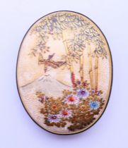 A Meiji period Satsuma belt buckle section, depicting Mount Fuji, bamboo trees and flowers.