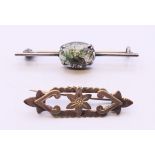 An antique silver brooch and a silver brooch set with a stone. Stone brooch 4.5 cm long.