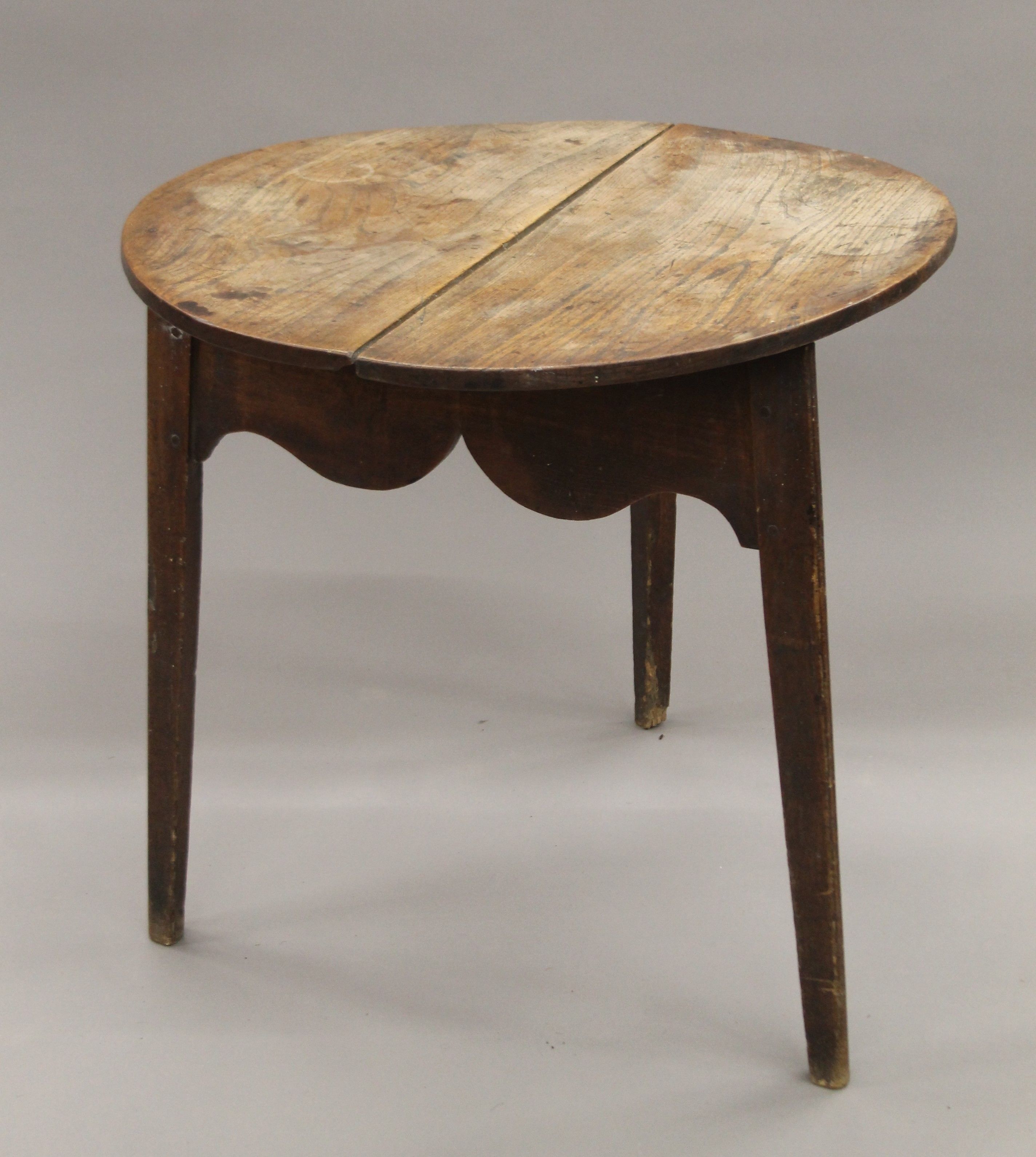 A Georgian elm cricket table. 71 cm diameter.