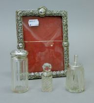 A silver frame and three silver-mounted bottles. The former 12.5 cm wide.