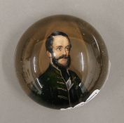 A 19th century glass paperweight painted with a gentleman. 8 cm diameter.
