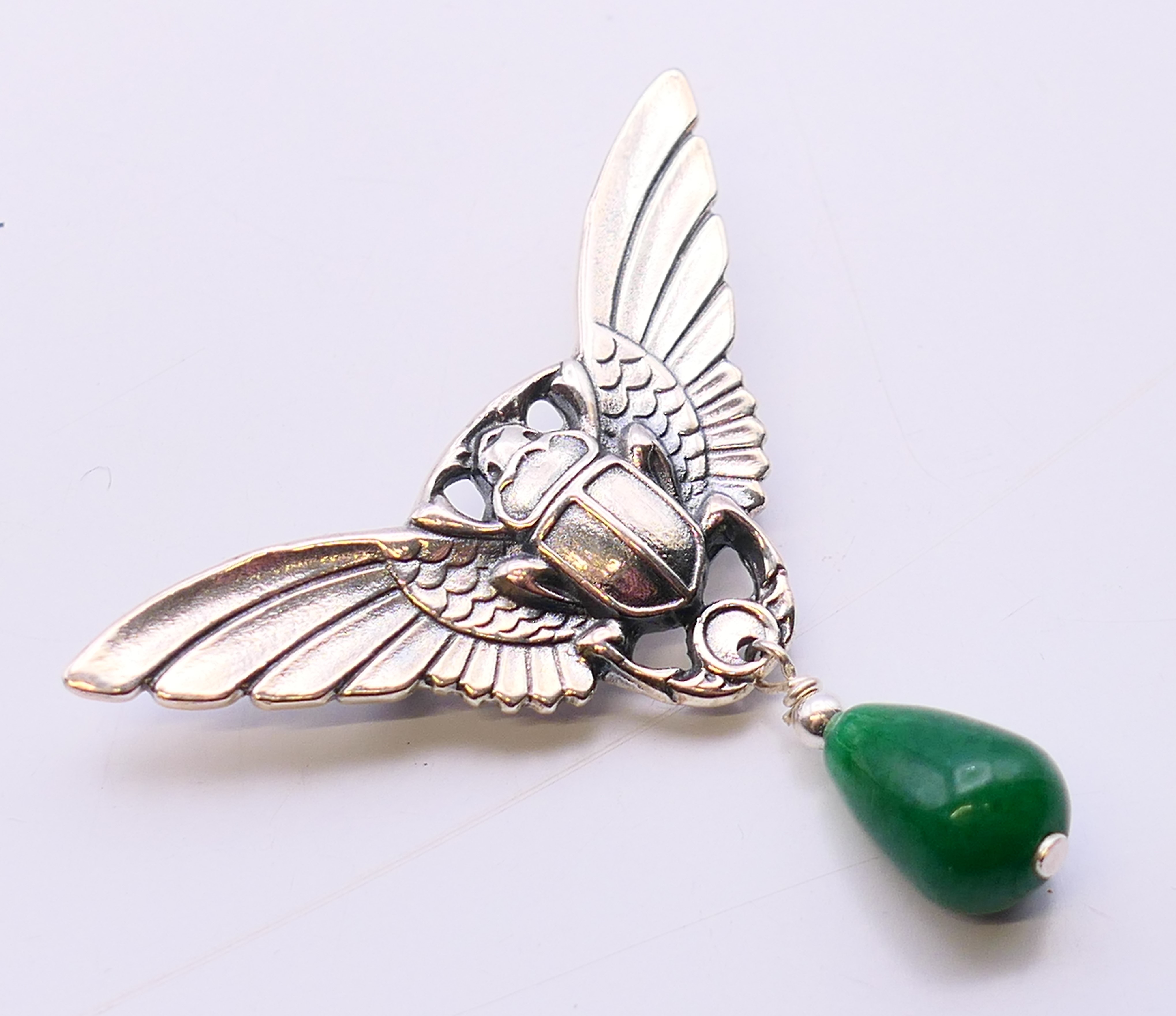 A silver and jade brooch in the form of a winged scarab beetle. 5 cm high x 5.5 cm wide. - Image 3 of 5