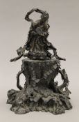 A 19th century Oriental bronze figure of Guanyin standing on a cast rockwork base with dragons.