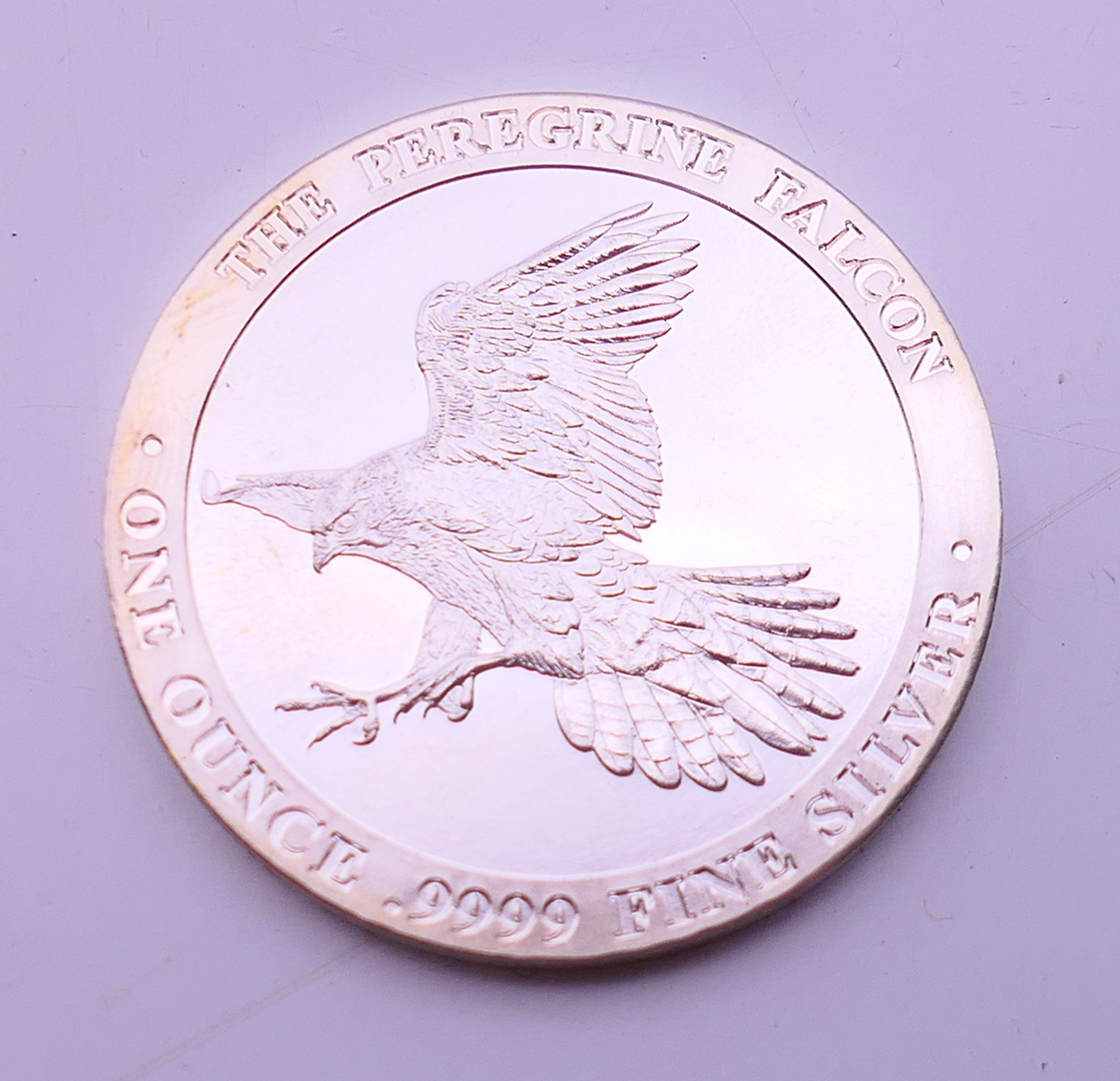 A .999 fine silver one ounce peregrine falcon coin. 4 cm diameter.