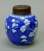 A 19th century Chinese prunus blossom porcelain ginger jar with pierced wooden cover. 13.5 cm high.