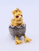 A silver pendant in the form of a chick in an egg bearing Russian marks. 2.5 cm high.